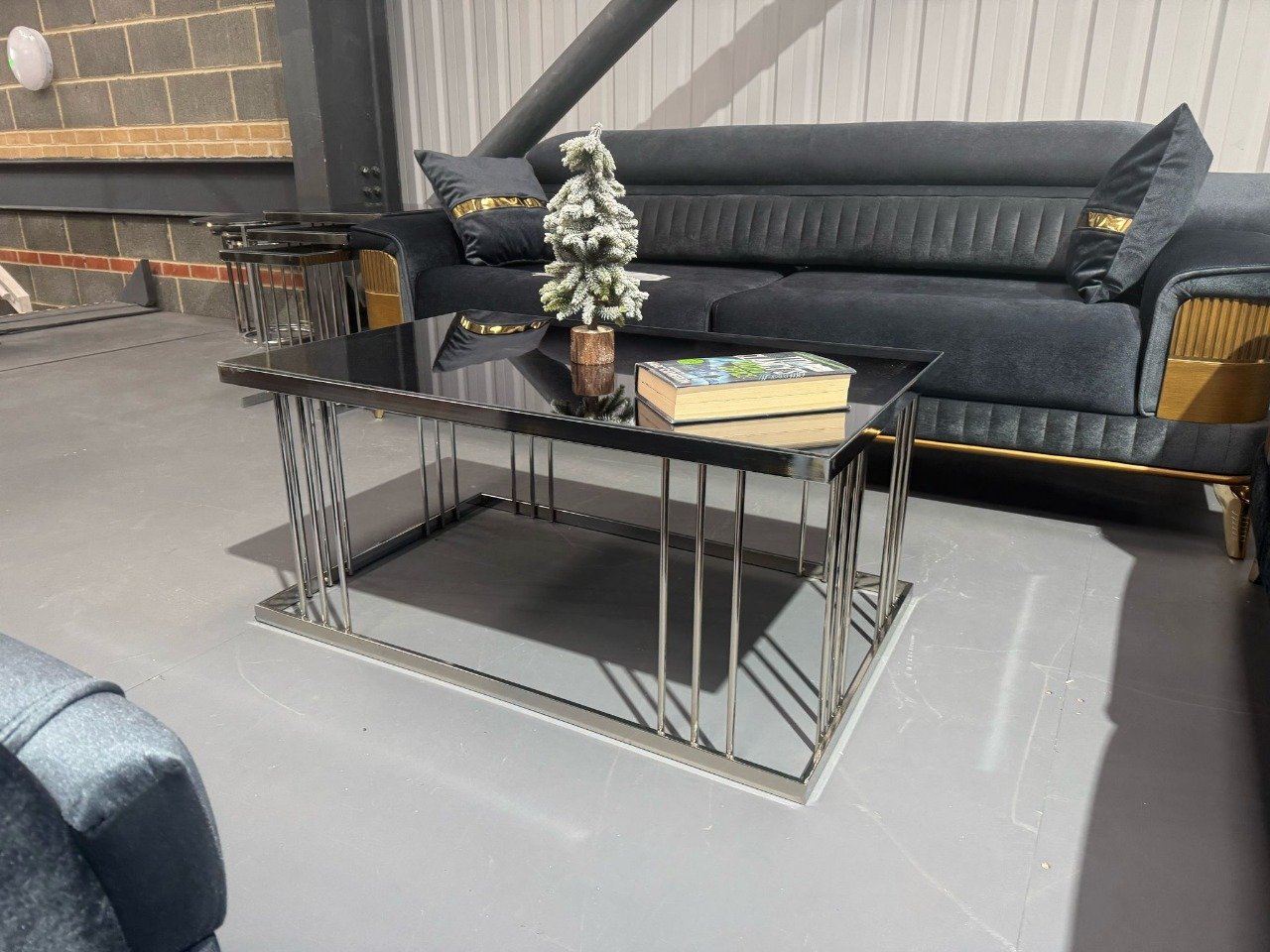 Modern Allegra Coffee Table with black glass top and chrome base in a living room.