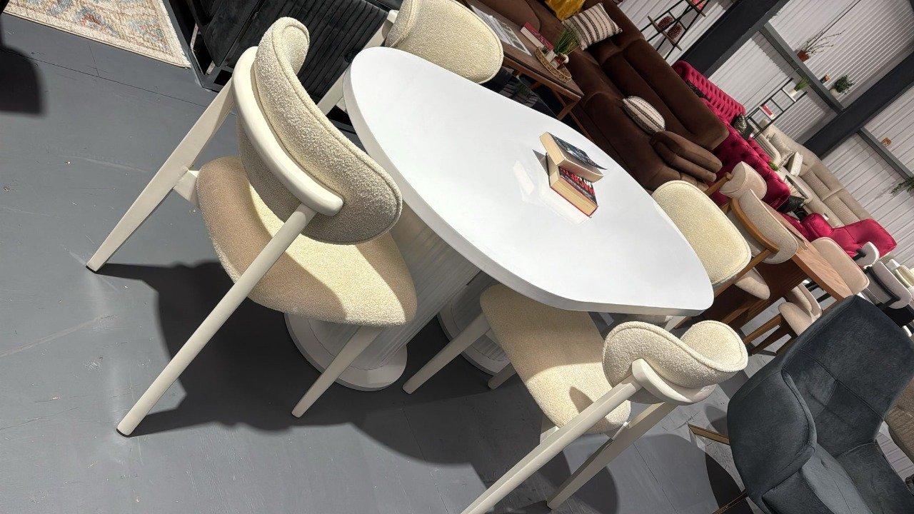 Elowen Classic Table Set with a white oval table and four matching cream-upholstered chairs.